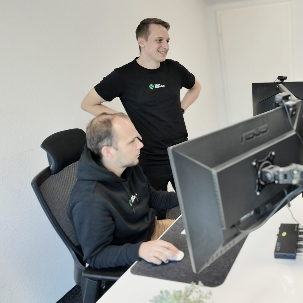 Zwei Personen analysieren Marketingdaten am Bildschirm